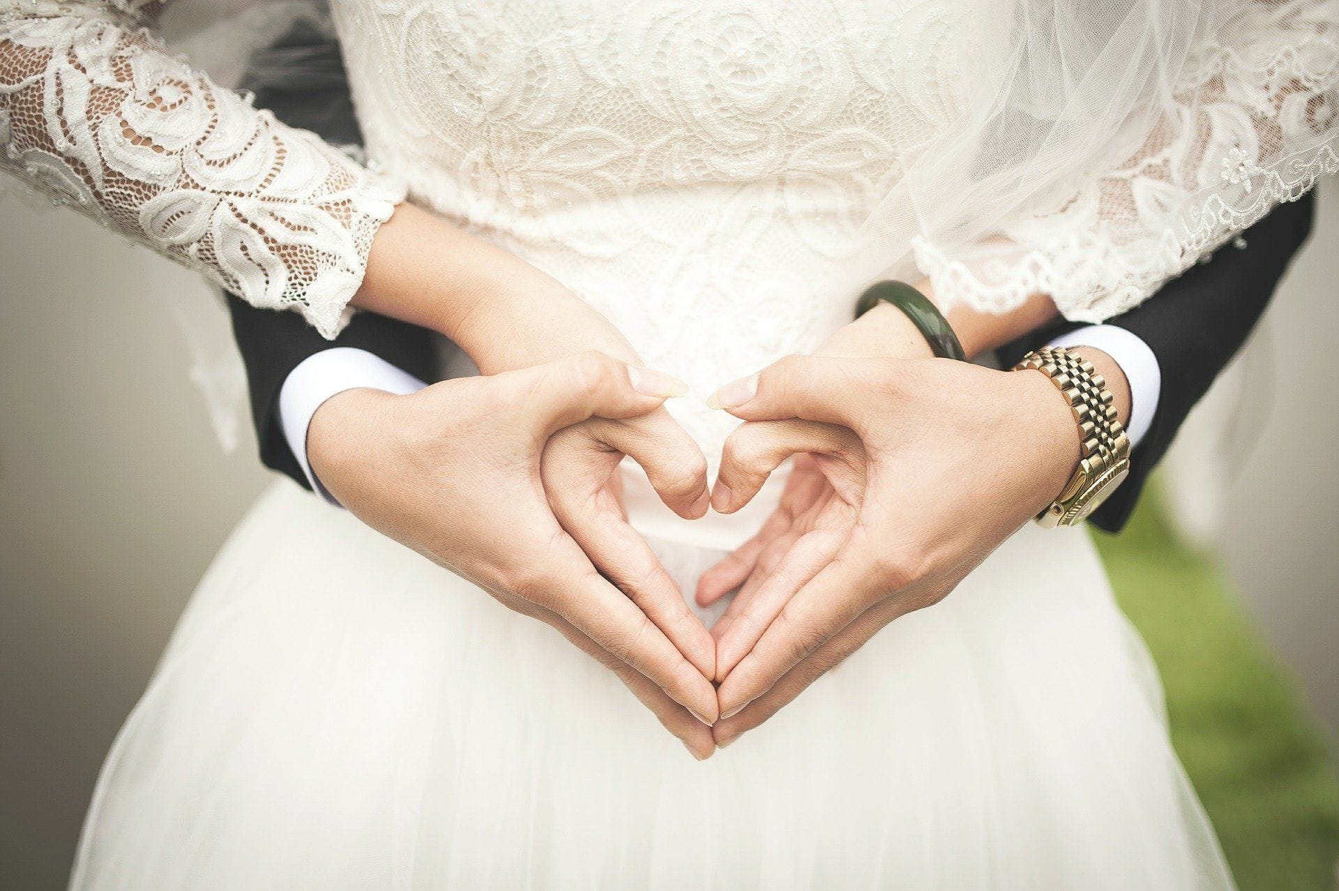 Bride and groom form a heart shape with their hands